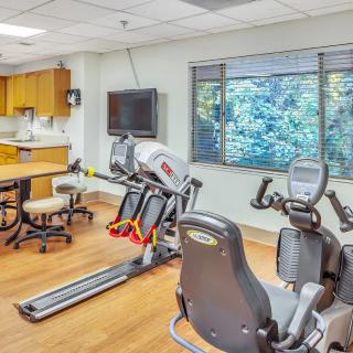 A fitness room featuring exercise equipment including a treadmill and stationary bike with a view of the outdoors.