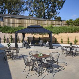 A well-furnished outdoor patio featuring a gazebo and several tables and chairs.