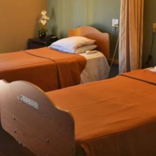 A hospital room with two neatly arranged beds, equipped for patient care.