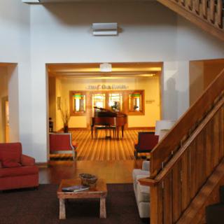 A cozy lobby area featuring a wooden staircase and comfortable seating.