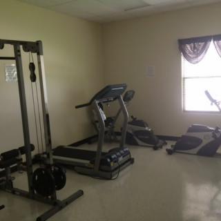 A small home gym with exercise equipment including a treadmill and weight machine.