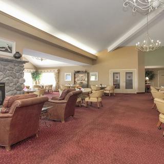 A spacious lounge area with comfortable seating, a fireplace, and elegant chandeliers.