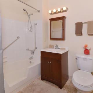 A clean and organized bathroom with a shower, vanity, and toilet.