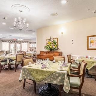 A cozy dining room with elegantly set tables, comfortable chairs, and tasteful decor.