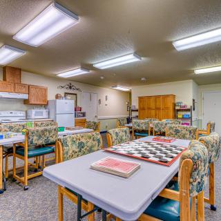 A spacious indoor kitchen and dining area with tables, chairs, and appliances.