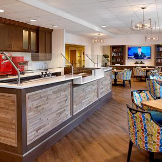 A modern kitchen and dining area with wooden flooring and stylish seating.