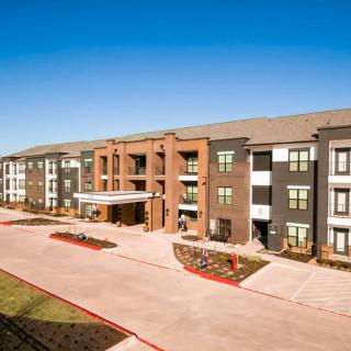 A modern residential apartment complex under a clear blue sky.