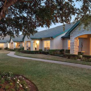 A peaceful residential area with a well-maintained garden and pathway during evening hours.
