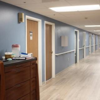 A quiet hospital hallway with doors on both sides and medical equipment.