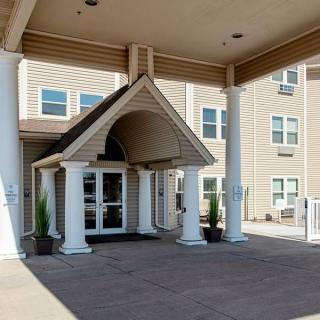The entrance of a hotel featuring columns and a covered walkway.