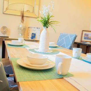 A beautifully set dining table with minimalist decor and a fresh flower centerpiece.