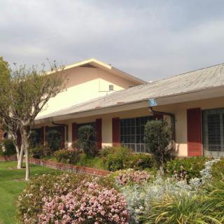 A charming building surrounded by lush gardens and colorful flowers.