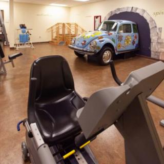 A gym featuring exercise equipment and a decorative Volkswagen Beetle.
