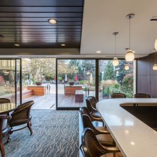 A modern indoor lounge featuring a bar counter and sliding glass doors leading to an outdoor area.