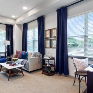 A modern living room featuring blue curtains, a comfortable sofa, and a stylish coffee table.