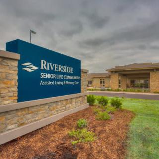 Exterior view of Riverside Senior Life Community with signage and landscaping.