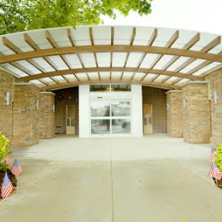 The welcoming entrance features a modern design with a stylish canopy.