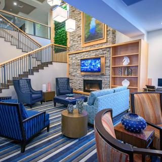 A modern living room with a cozy seating area, featuring a fireplace and television, complemented by elegant furniture and decor.