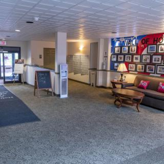 A welcoming lobby with comfortable seating and a display of framed pictures on the wall.
