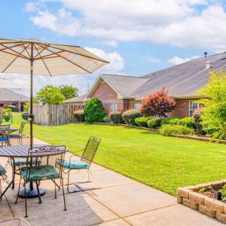 A beautifully maintained backyard with patio seating and lush green lawn.