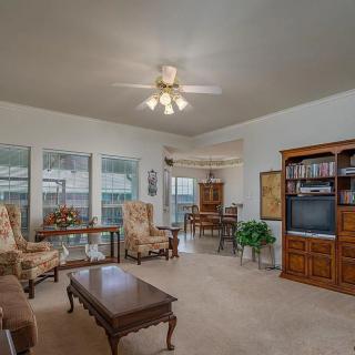 A cozy living room with classic furniture and a ceiling fan.