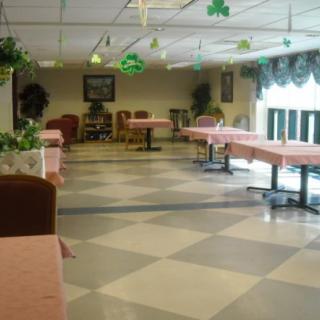 An empty dining area with tables and chairs, decorated with hanging ornaments.