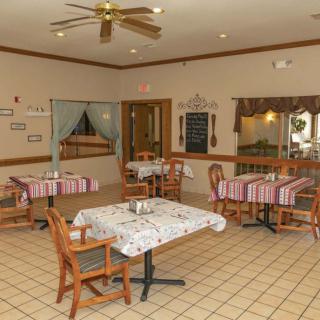 Cozy dining area with tables and chairs arranged neatly, featuring a warm and inviting interior decor.