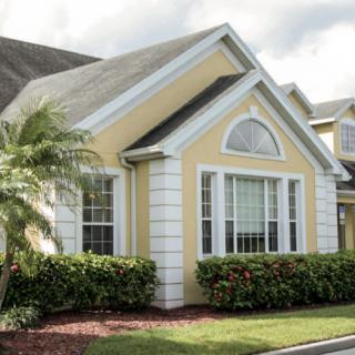 A suburban residential house with a yellow exterior and well-maintained landscaping.