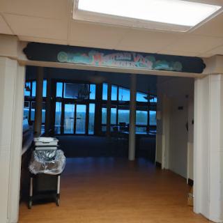 An entrance to a hospital reception area with large windows and clear signage.