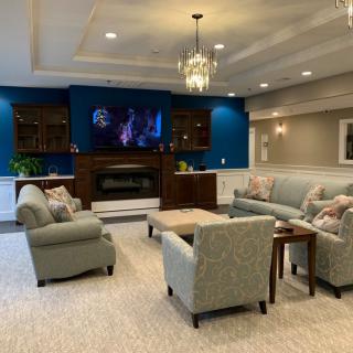 A well-furnished living room with a cozy seating area, fireplace, and TV.