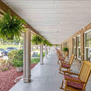 A serene porch with rocking chairs and hanging plants.
