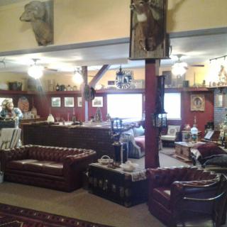A rustic lounge area featuring leather sofas and wooden decor.