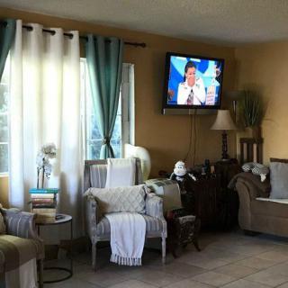 A cozy living room with a wall-mounted television, comfortable seating, and tasteful decor.