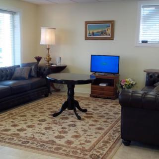 A cozy living room with two sofas, a small round coffee table, and a TV on a stand.