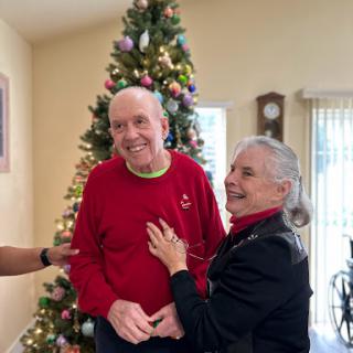 A joyful holiday moment shared among loved ones in front of a beautifully decorated Christmas tree.