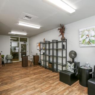 A modern salon interior with wooden flooring and decorative elements.