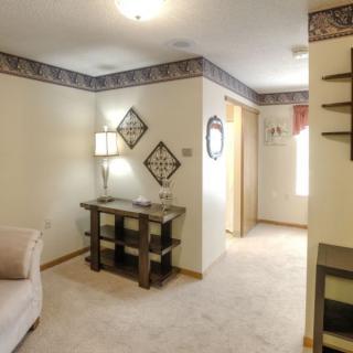 A cozy living room with a sofa, table, and decorative elements on the walls.