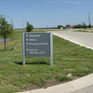 Directional sign indicating the way to a hospital and other locations.