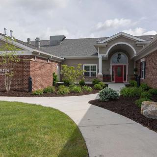 A well-maintained building entrance with a landscaped garden and pathway.