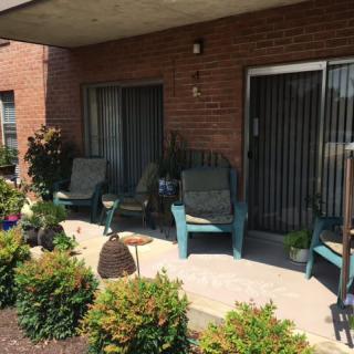 Cozy patio area with comfortable chairs and lush plants.