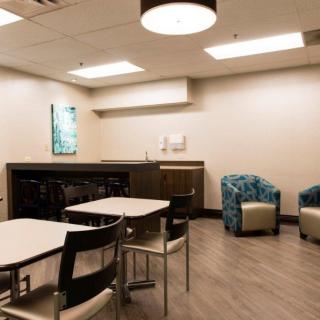 A modern break room with tables, chairs, and a cozy lounge area.