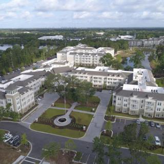 Aerial view of a modern residential complex surrounded by landscaped areas.