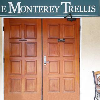 Entrance to the Monterey Trellis with wooden doors and signage.