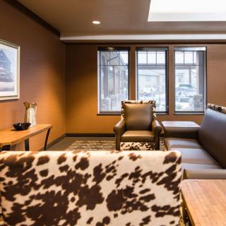 A cozy living room with a cowhide-patterned chair and comfortable seating.
