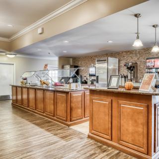 A modern cafe interior with a wood-finished counter and stylish lighting.