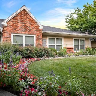 A charming house with a well-maintained garden and colorful flower beds.