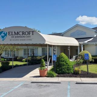 Entrance to a senior living facility with landscaped surroundings and a covered walkway.