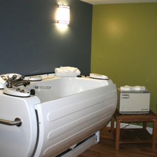 A modern spa treatment room featuring a therapeutic bathtub.