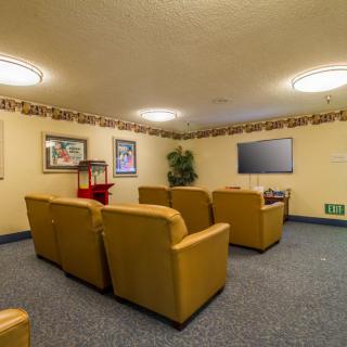 A cozy theater room with comfortable seating and a large television.