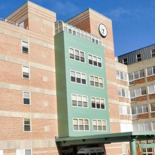 A hospital building with a clock on the facade.